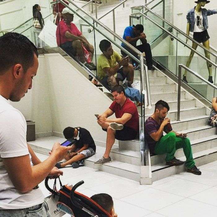 Foto di uomini costretti ad aspettare gli altri mentre fanno shopping