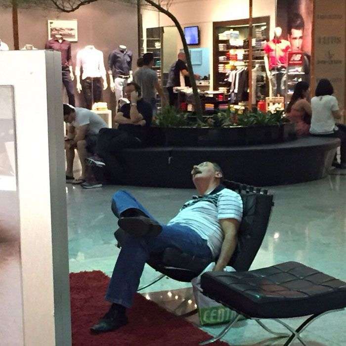 Foto di uomini costretti ad aspettare gli altri mentre fanno shopping