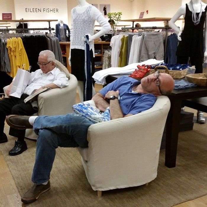 Foto di uomini costretti ad aspettare gli altri mentre fanno shopping
