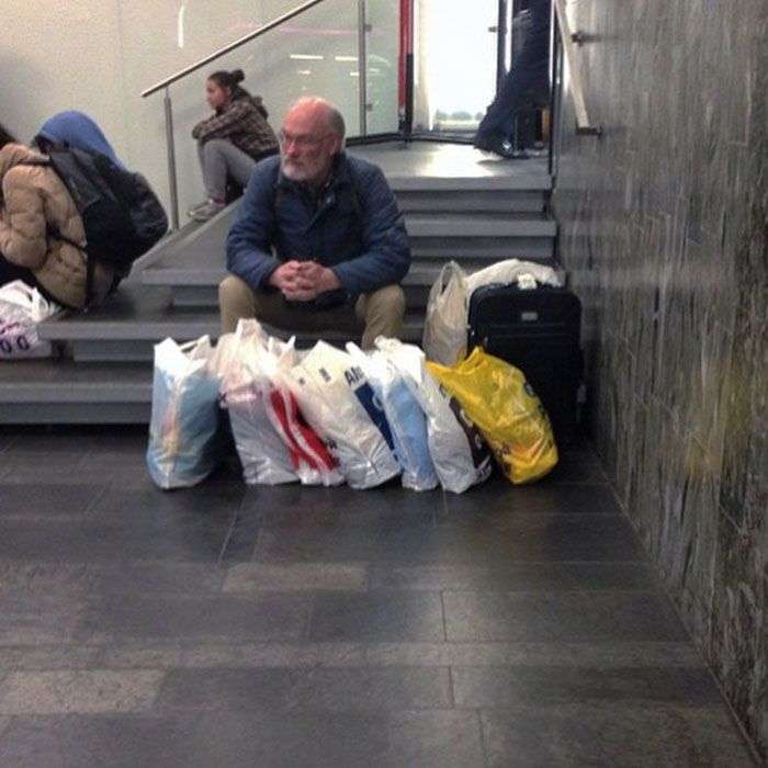 Foto di uomini costretti ad aspettare gli altri mentre fanno shopping