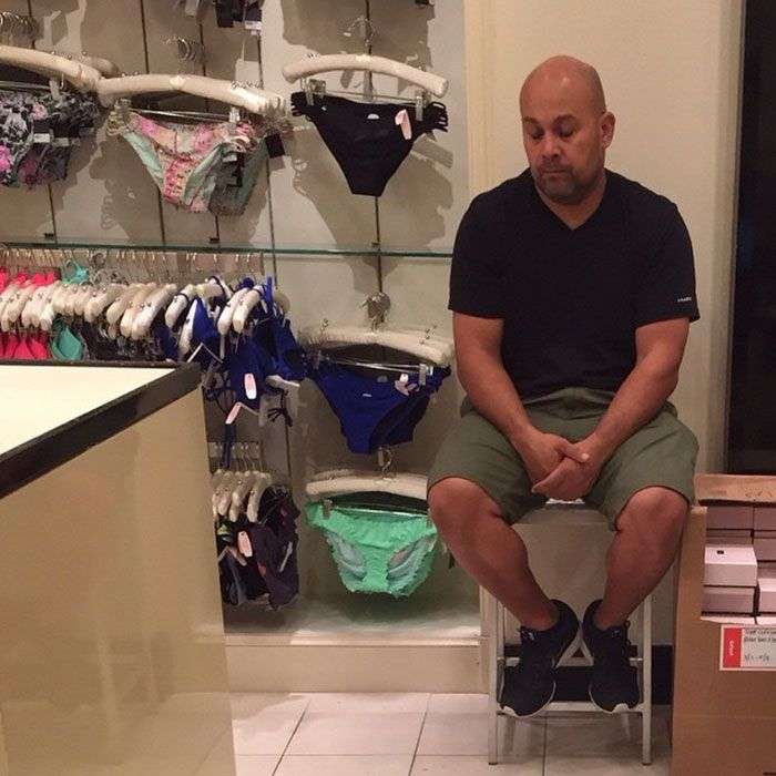 Foto di uomini costretti ad aspettare gli altri mentre fanno shopping