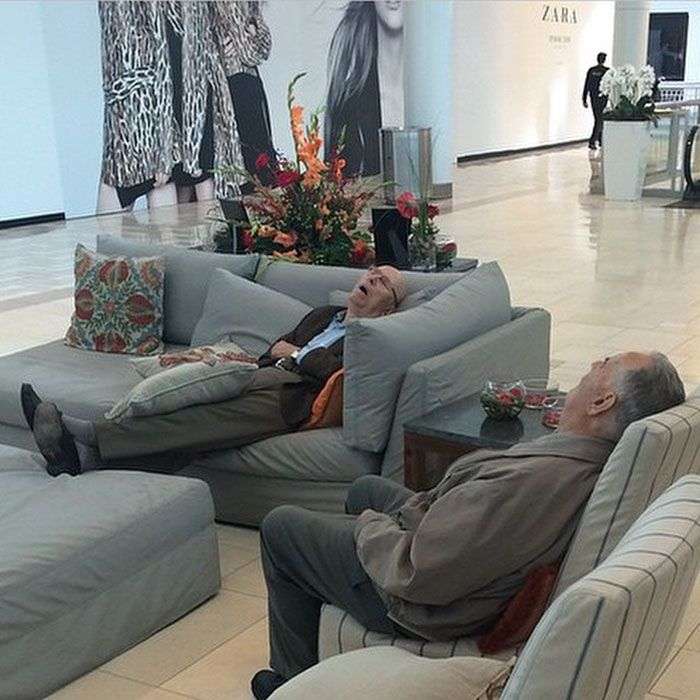 Foto di uomini costretti ad aspettare gli altri mentre fanno shopping